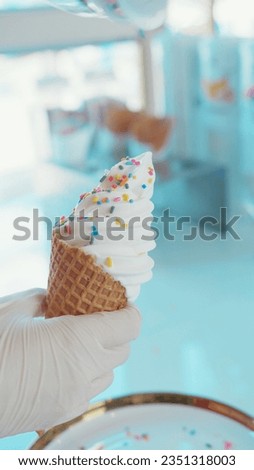Cooking vanilla ice cream in a bean cup that is sprinkled with multi-colored sugar sprinkles
