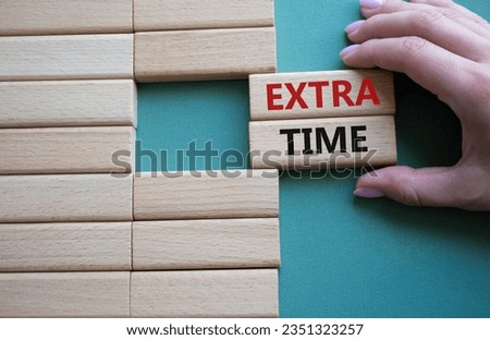 Extra time symbol. Concept word Extra time on wooden blocks. Businessman hand. Beautiful grey green background. Business and Extra time concept. Copy space