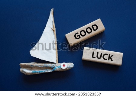 Good luck symbol. Wooden blocks with words Good luck. Beautiful deep blue background with boat. Business and Good luck concept. Copy space.