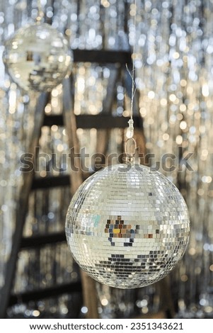 A large mirror ball on a shiny background. Reflective surface to create a lighting effect.