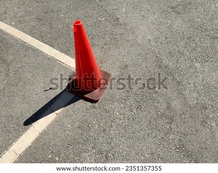 Orange traffic cone with white line on the street