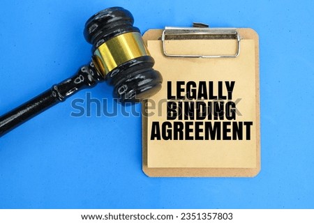 a judge's hammer and a whiteboard with the wording of a legally binding agreement. the concept of mutual consent. Royalty-Free Stock Photo #2351357803
