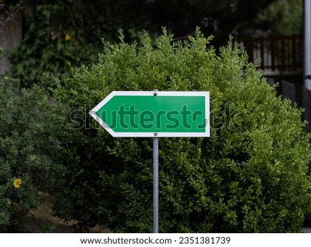 Empty green arrow sign with a blank space for content, directing to the left side. Template or mockup for a creative use. Royalty-Free Stock Photo #2351381739