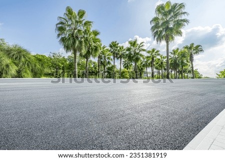 Asphalt road and tropical woods background Royalty-Free Stock Photo #2351381919