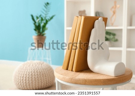 Stylish holder for books on coffee table in room