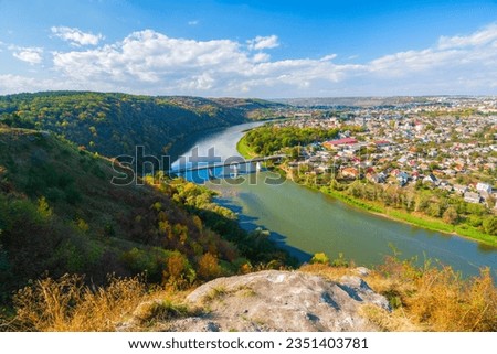 Scenic aerial autumn view on the Dniester River with bridge and Zalishchyky town. Location place: National Natural Park Dniester Canyon, Ukraine.