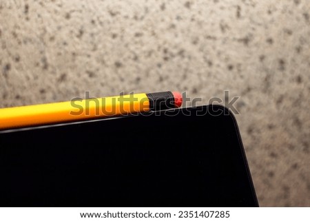 The stylus in the form of a pencil lies on a tablet computer