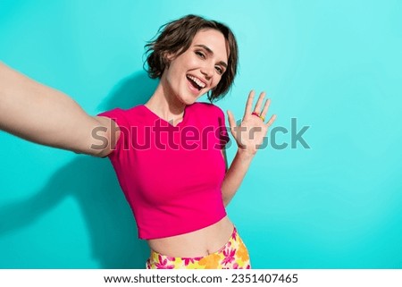 Portrait of cute positive lady toothy smile take selfie video call arm palm waving hi isolated on turquoise color background Royalty-Free Stock Photo #2351407465