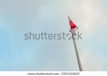 The red and white flag of the Republic of Indonesia still flies in the afternoon