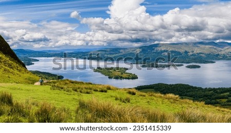 Hikers descending Conic Hill towards Loch Lomond with beautiful mountain scenery (Balmaha) Royalty-Free Stock Photo #2351415339