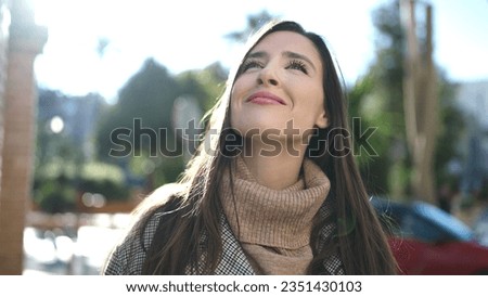 Beautiful hispanic woman smiling confident looking at the sky at street Royalty-Free Stock Photo #2351430103