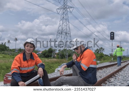 service worker with freight train oil transport on background. Portrait engineer on railway.  railway engineer and design working as team Royalty-Free Stock Photo #2351437027