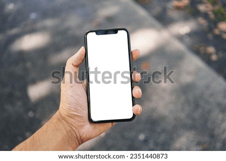Man holding smartphone showing white blank screen at street