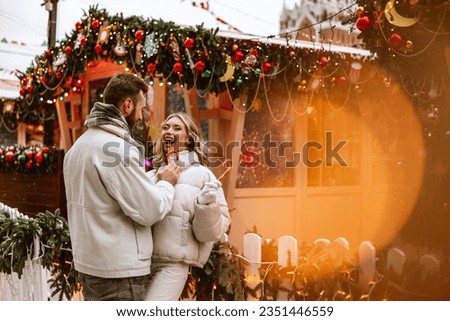 happy couple of young people, a man and a woman, have fun on Red Square in Moscow during the Christmas and New Year holidays at a festive fair