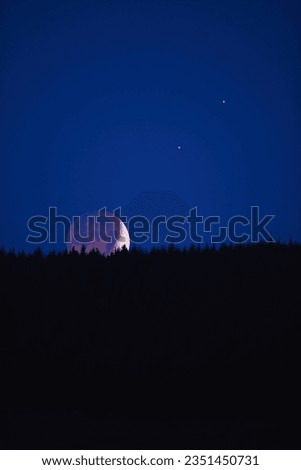 Waxing crescent Moon, planets and stars rising behind mountain silhouettes.
