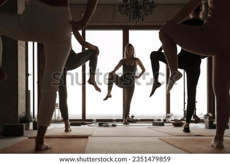 Group of girls practicing yoga and meditation in a city apartment with panoramic views