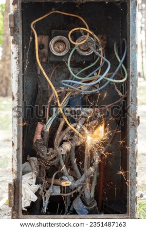 Vintage breaker box with dirty wires, sparks and flame, short circuit concept Royalty-Free Stock Photo #2351487163