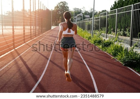 
photo back view woman running on track