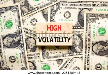 High volatility symbol. Concept words High volatility on beautiful wooden blocks. Dollar bills. Beautiful background from dollar bills. Business high volatility concept. Copy space.