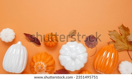 Set of ceramic pumpkins and candles on orange background. Fall decor, interior decoration. Flat lay, top view, copy space
