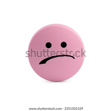 Pink pill with sad face on white background
