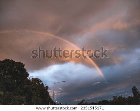 The evening sky was not very colorful but there were still thick clouds and a rainbow circled through the clouds.