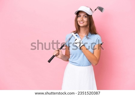 Young golfer player man isolated on pink background pointing to the side to present a product