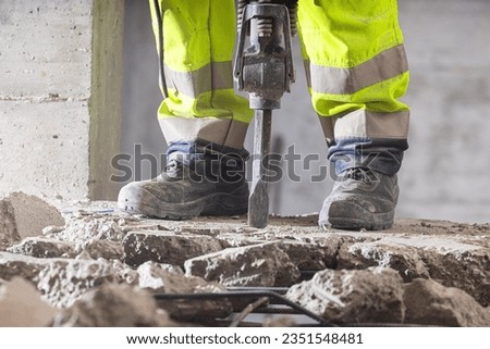 Close up view of heavy-duty jackhammer crushing concrete. Royalty-Free Stock Photo #2351548481