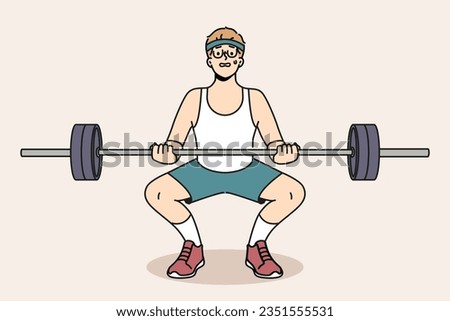 Man with barbell goes in for sports in gym, wanting to have beautiful figure and healthy body. Guy novice bodybuilder squats with barbell in hands and needs help of fitness trainer. Royalty-Free Stock Photo #2351555531
