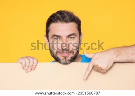 Man holds sign with copy space. Placard ready for copy space product. Sign to your copy space text. Man showing blank sign board on studio background, pointing finger. Empty copy space blank board.
