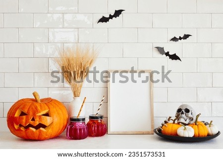 Happy Halloween concept. Picture frame with blank card, Jack o lantern, pumpkins, bats, Halloween decorations in cozy home interior.