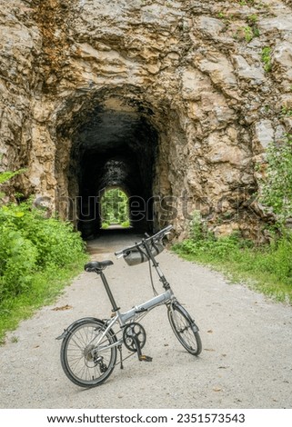 folding bike on Katy Trail at a tunnel near Rocheport, Missouri, summer scenery. The Katy Trail is 237 mile bike trail converted from an old railroad. Royalty-Free Stock Photo #2351573543