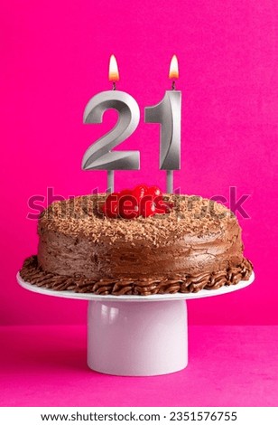 Number 21 candle - Chocolate cake on pink background
