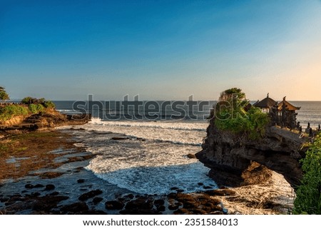 Pura Batu Bolong is the traditional Balinese temple located on a rocky, in the Tanah Lot area, Bali, Indonesia. It a Hindu Temple on the Beatiful Rock Royalty-Free Stock Photo #2351584013
