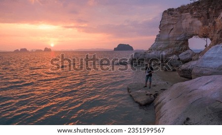 photographer take picture by drone in front of the hole in the cape  during sunset time.Leam Jamookkwy or Buffalo Nose cape is in Thalane Krabi