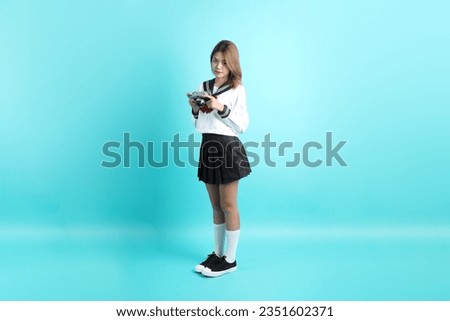 The Asian girl in Japanese student uniform standing on the green background.