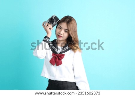 The Asian girl in Japanese student uniform standing on the green background.