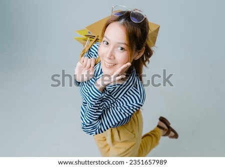 Asian woman carrying colorful shopping bags, young woman sitting and use smartphone for shopping online, Asian beautiful women shopping online