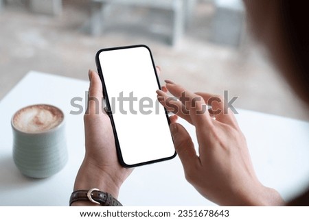 Mockup, woman's hand holding using mobile phone at coffee shop with copy space, white blank screen for text, mobile app design and advertising, online marketing