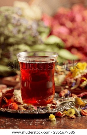 Herbal tea and a mix of various dried medicinal plants and herbs on a brown vintage background.