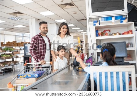 Indian woman giving bank card for payment after shopping. Royalty-Free Stock Photo #2351680775
