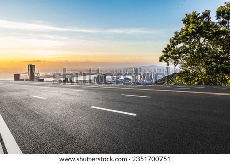 Asphalt highway and skyline with modern buildings at sunset Royalty-Free Stock Photo #2351700751