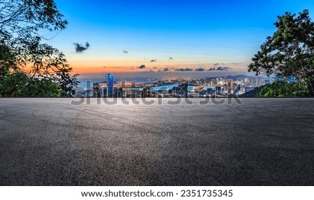 Asphalt road and city skyline with modern buildings at sunset by the sea Royalty-Free Stock Photo #2351735345