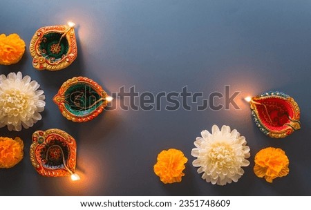 Happy Diwali - Clay Diya lamps lit during Diwali, Hindu festival of lights celebration. Colorful traditional oil lamp diya on blue background Royalty-Free Stock Photo #2351748609