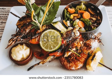 Delicious barbecued fish and vegetable seafood dish in a white plate