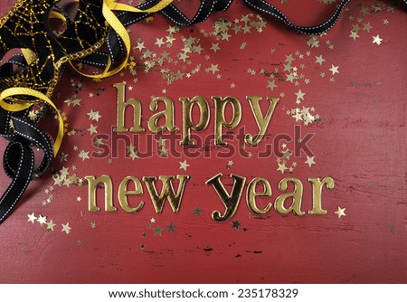 Happy New Year gold letters and decorations on red rustic distressed vintage wood.