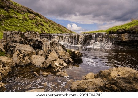 This is the stream above Hull Pot near Pen-y-Ghent in ribblesdale in the Yorkshire Dales. Here it flows over a rock shelf creating a mini waterfall. Royalty-Free Stock Photo #2351784745