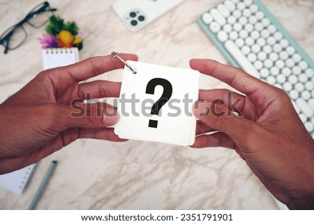 Question mark on notebook in asian man hand. concept for confusion, question or solution