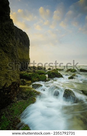 lanscape views of indrayanti beach yogyakarta gunungkidul indonesia  cliffs and rocks on the seafront with beautiful clouds at sunrise or sunset Royalty-Free Stock Photo #2351792731