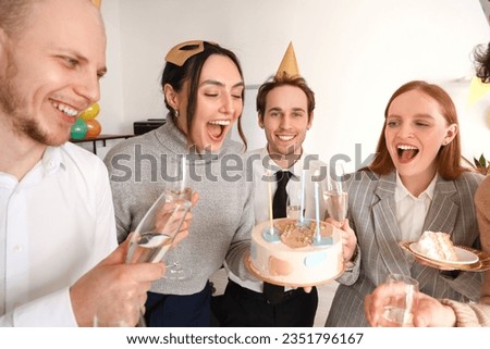 Group of young friends with champagne celebrating Birthday in office